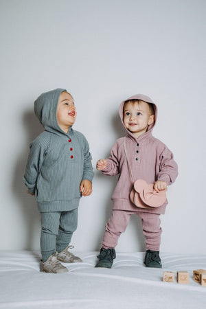 two toddlers standing and laughing