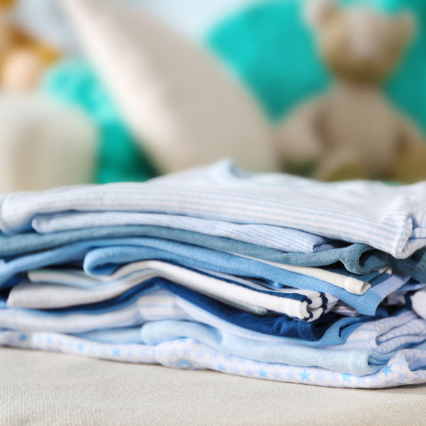 pile of folded blue baby clothes