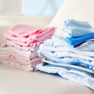 bundle of folded baby clothes in pink and blue