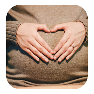 pregnant woman holding her tummy and forming a heart with her hands