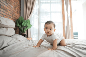 toddler crawling on a bed